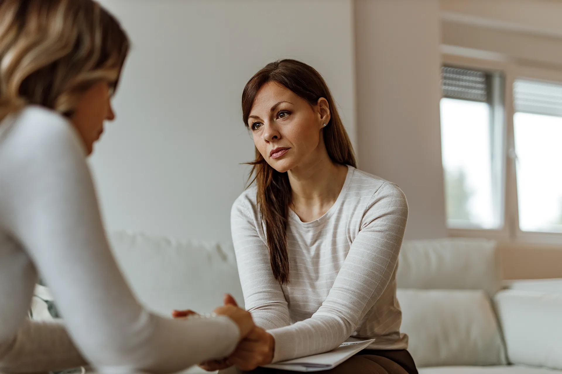 A concerned friend or therapist listens intently to another person, offering support and a safe space for conversation.