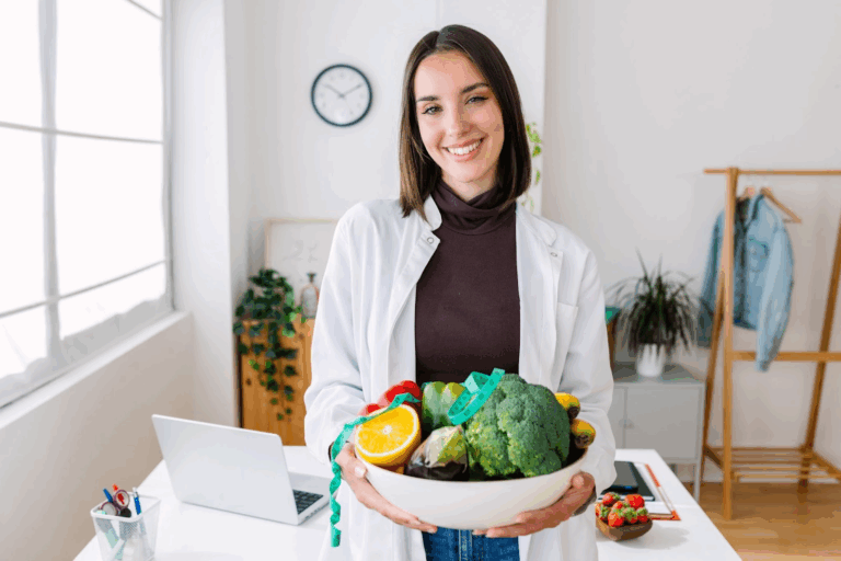 A nutritionist holds a bowl of fruit in her office.