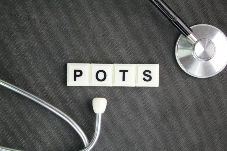Word “POTS” written on letter tiles next to a medical tool. 